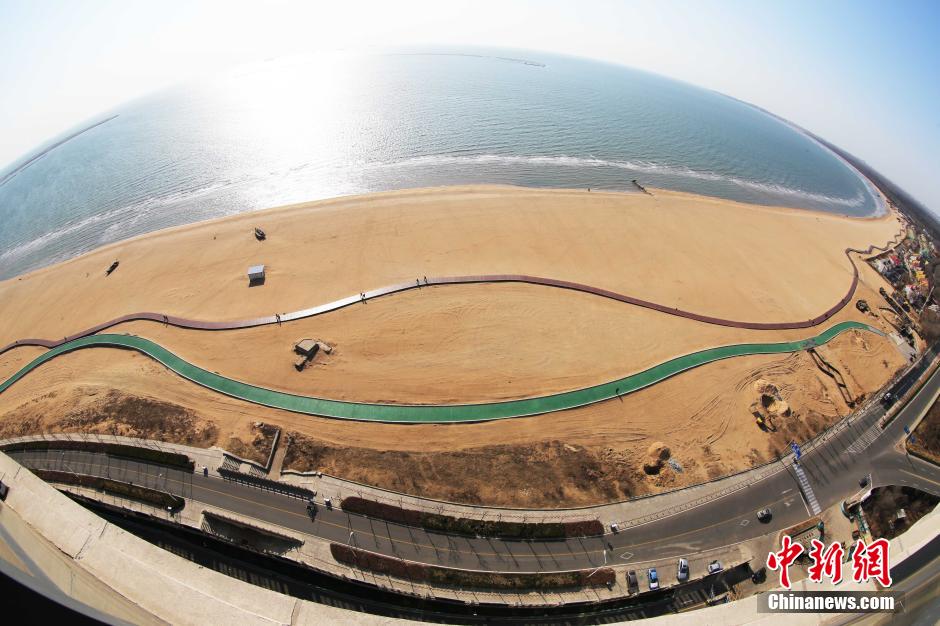 3月13日，秦皇島萬米臨海沙灘木棧道。據了解，該木棧道全長約4200米，與北戴河區(qū)原有的7500米木棧道對接后全線總長度1.17萬米，整個木棧道東起秦皇島體育基地游船碼頭，西至北戴河濕地公園，呈波浪形蜿蜒10.4公里海岸線。 中新社發(fā) 曹建雄 攝 CNSPHOTO
